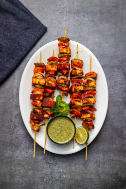 Ünlü Hint yemeğinin seçici odağı Paneer Tikka Masala Tandoor ya da koyu arkaplanı olan Paneer Kebap.