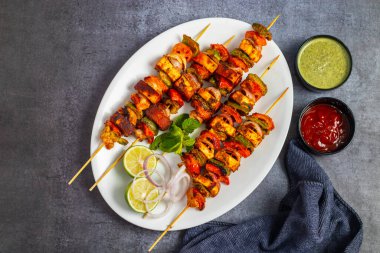 Ünlü Hint yemeğinin seçici odağı Paneer Tikka Masala Tandoor ya da koyu arkaplanı olan Paneer Kebap.