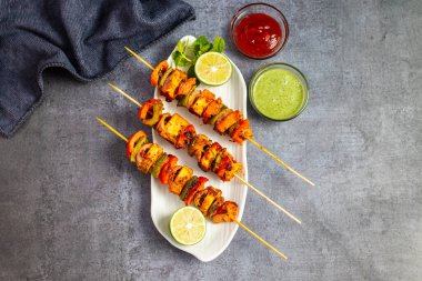 Ünlü Hint yemeğinin seçici odağı Paneer Tikka Masala Tandoor ya da koyu arkaplanı olan Paneer Kebap.