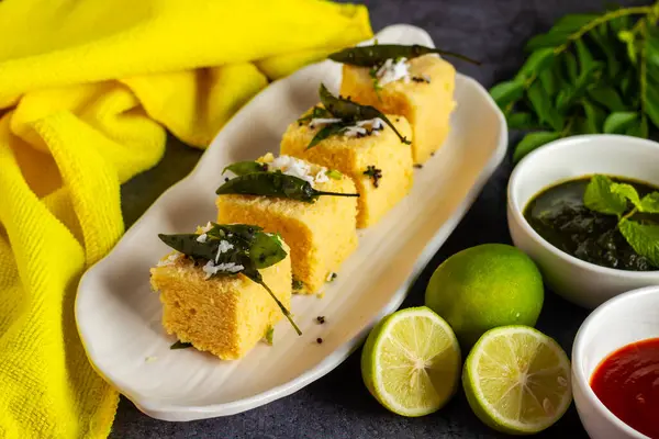 stock image Selective focus of popular Gujrati food Dhokla with mint chutney and black background. 