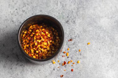 Aromatik yemek aperatifleri seramik zeminli cam kavanozda kırmızı biber taneleri. Seçici odak.  