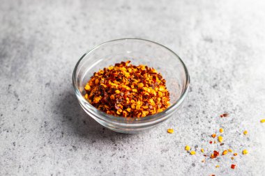 Aromatik yemek aperatifleri seramik zeminli cam kavanozda kırmızı biber taneleri. Seçici odak.  