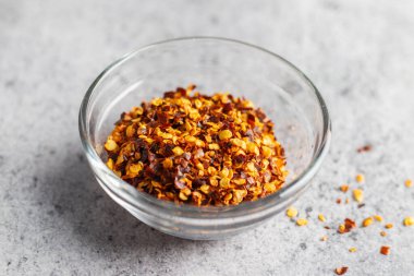 Aromatik yemek aperatifleri seramik zeminli cam kavanozda kırmızı biber taneleri. Seçici odak.  