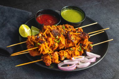 Lezzetli Baharatlı Tavuk Tikka Kebap, Tangy Marinade ile Lezzetli Izgara Lezzet ve Nane ve Domates soslu Tütsülenmiş Kömür Aroma Servisi. Seçici odak.