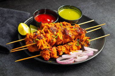 Lezzetli Baharatlı Tavuk Tikka Kebap, Tangy Marinade ile Lezzetli Izgara Lezzet ve Nane ve Domates soslu Tütsülenmiş Kömür Aroma Servisi. Seçici odak.