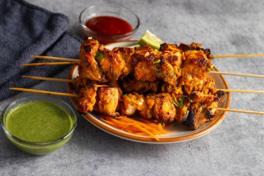 Lezzetli Baharatlı Tavuk Tikka Kebap, Tangy Marinade ile Lezzetli Izgara Lezzet ve Nane ve Domates soslu Tütsülenmiş Kömür Aroma Servisi. Seçici odak.