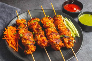 Lezzetli Baharatlı Tavuk Tikka Kebap, Tangy Marinade ile Lezzetli Izgara Lezzet ve Nane ve Domates soslu Tütsülenmiş Kömür Aroma Servisi. Seçici odak.