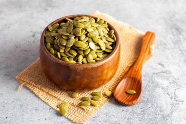 Tahta bir kasede bal kabağı tohumlarının seçici odak noktası, sağlık için iyidir.. 