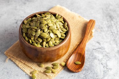 Tahta bir kasede bal kabağı tohumlarının seçici odak noktası, sağlık için iyidir.. 