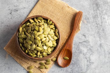 Tahta bir kasede bal kabağı tohumlarının seçici odak noktası, sağlık için iyidir.. 