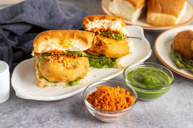 Mumbai 'nin ünlü sokak yemeklerinin seçmeli odak noktası lezzetli Vada Pav kişniş, turşu, domates sosu, kuru sarımsaklı baharat ve kızarmış kırmızı biber..