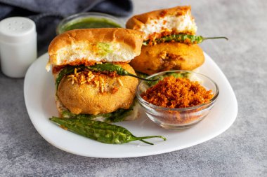 Mumbai 'nin ünlü sokak yemeklerinin seçmeli odak noktası lezzetli Vada Pav kişniş, turşu, domates sosu, kuru sarımsaklı baharat ve kızarmış kırmızı biber..