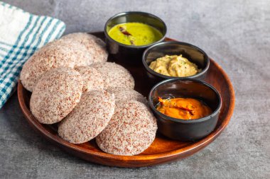 Ragi idli is a healthy, steamed South Indian dish made from fermented ragi (finger millet) batter, soft, and nutritious. clipart