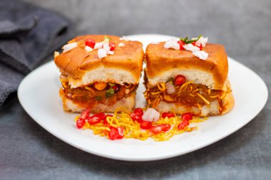 Dabeli is a popular Indian street food from Gujarat, consisting of spiced mashed potatoes stuffed in a bun with chutneys. clipart