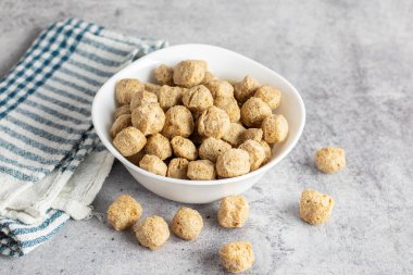 Çiğ soya parçaları, genellikle vejetaryen yemeklerde kullanılan, kurutulmuş soya unundan yapılan, protein zengini, bitkisel etlerden oluşan, susuz kalmış et parçaları..