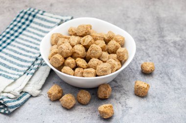 Çiğ soya parçaları, genellikle vejetaryen yemeklerde kullanılan, kurutulmuş soya unundan yapılan, protein zengini, bitkisel etlerden oluşan, susuz kalmış et parçaları..