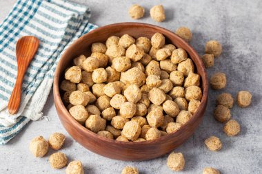 Çiğ soya parçaları, genellikle vejetaryen yemeklerde kullanılan, kurutulmuş soya unundan yapılan, protein zengini, bitkisel etlerden oluşan, susuz kalmış et parçaları..