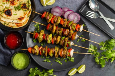 Hariyali Tavuğu Tikka Kebap nane, kişniş ve baharatlarla marine edilmiş mükemmel ızgara edilmiş tavuk ile yapılan lezzetli bir Hint yemeğidir..