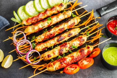 Lezzetli ızgara tavuk kebabı. Lezzetli bir yemek için taze nane sosu ve keskin domates sosuyla servis ediliyor..