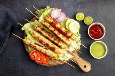 Lezzetli ızgara tavuk kebabı. Lezzetli bir yemek için taze nane sosu ve keskin domates sosuyla servis ediliyor..