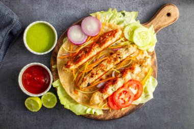 Lezzetli ızgara tavuk kebabı. Lezzetli bir yemek için taze nane sosu ve keskin domates sosuyla servis ediliyor..