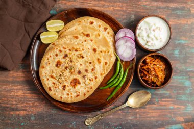 Sattu paratha is a popular stuffed flatbread from Uttar Pradesh and Bihar, served with tangy pickle and cooling raita. clipart