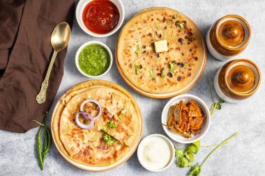 Aloo paratha is a popular North Indian dish, especially in Punjab, Uttar Pradesh, and Bihar. It's a stuffed flatbread with spiced mashed potatoes, served with butter and tangy achar (pickle). clipart