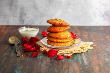 Malpua is a traditional Indian dessert made from flour, sugar, and coconut, deep-fried until crispy, then soaked in sweet syrup, often flavored with cardamom. clipart