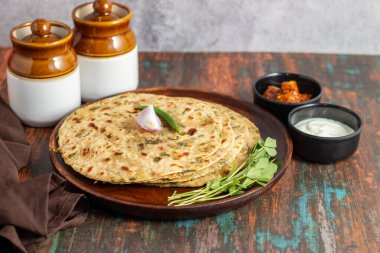 Methi paratha is a savory Indian flatbread made with fenugreek leaves, whole wheat flour, spices, and ghee, offering a flavorful, aromatic, and nutritious meal. clipart