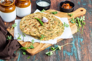 Methi paratha is a savory Indian flatbread made with fenugreek leaves, whole wheat flour, spices, and ghee, offering a flavorful, aromatic, and nutritious meal. clipart