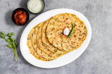 Methi paratha is a savory Indian flatbread made with fenugreek leaves, whole wheat flour, spices, and ghee, offering a flavorful, aromatic, and nutritious meal. clipart