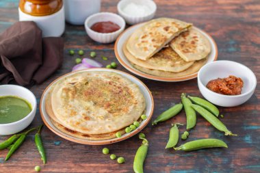 Matar paratha baharatlı yeşil bezelye püresiyle doldurulmuş lezzetli bir Hint ekmeğidir. Altın olana kadar pişirilir ve baharatla servis edilir..