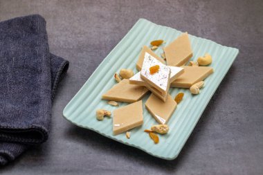 Kaju Katli, kaju fıstığı, şeker ve ghee 'den yapılan zengin, pürüzsüz bir Hint tatlısıdır. Kakule ile lezzetlidir ve genellikle gümüş yapraklarla süslenir..