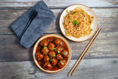 Lezzetli bir Hint-Çin yemeği için baharatlı, keskin soslu, aromalı kızarmış erişteyle servis edilen mançurya köfteleri..