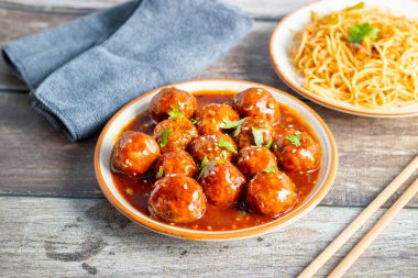 Lezzetli bir Hint-Çin yemeği için baharatlı, keskin soslu, aromalı kızarmış erişteyle servis edilen mançurya köfteleri..