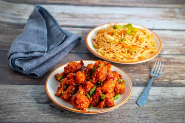 Baharatlı, keskin soslu çıtır Gobi Mançurya peyniri yanında sebzeli, sarımsaklı ve soya aromalı erişte. Lezzetli bir Hint-Çin lezzeti.!