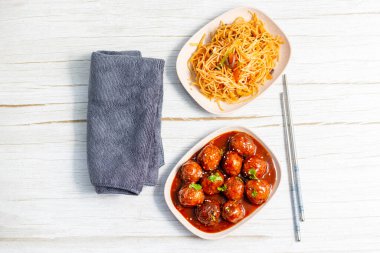 Lezzetli bir Hint-Çin yemeği için baharatlı, keskin soslu, aromalı kızarmış erişteyle servis edilen mançurya köfteleri..