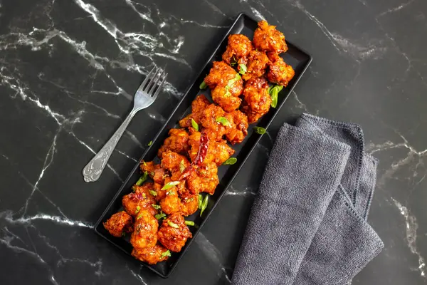 Gobi Mançurya, haşlanmış, kızartılmış ve soya-sarımsak sosuna batırılmış Hint-Çin karışımı baharatlı bir yemektir..