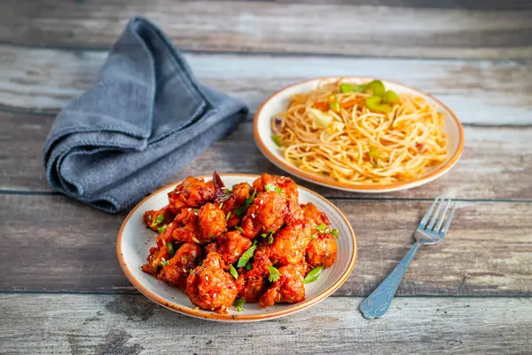 Baharatlı, keskin soslu çıtır Gobi Mançurya peyniri yanında sebzeli, sarımsaklı ve soya aromalı erişte. Lezzetli bir Hint-Çin lezzeti.!