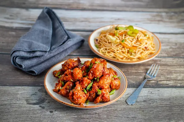 Baharatlı, keskin soslu çıtır Gobi Mançurya peyniri yanında sebzeli, sarımsaklı ve soya aromalı erişte. Lezzetli bir Hint-Çin lezzeti.!