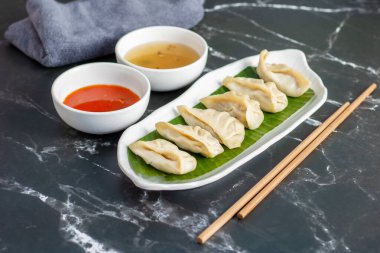  Momo, Nepal, Tibet ve Butan 'da baharatlı turşuyla servis edilen et ya da sebzelerle dolu buğulanmış ya da kızartılmış hamur köfteleri..