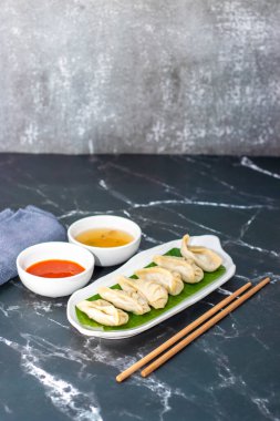  Momo, Nepal, Tibet ve Butan 'da baharatlı turşuyla servis edilen et ya da sebzelerle dolu buğulanmış ya da kızartılmış hamur köfteleri..