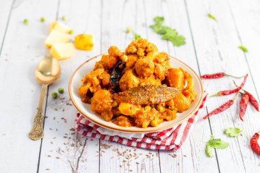 Aloo Phulkopir Dalna, baharat, domates ve zencefilli sosla pişirilmiş Bengal patatesi ve karnabahar körisidir..