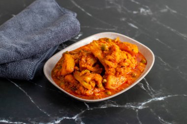 Aloo Phulkopir Dalna, baharat, domates ve zencefilli sosla pişirilmiş Bengal patatesi ve karnabahar körisidir..