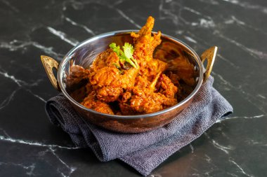 Tavuk Bhuna Masala, kalın, baharatlı ve aromalı domates soslu yumuşak tavuklu zengin, aromatik bir Hint yemeğidir..