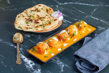 Zengin, baharatlı kaju soslu, yumuşak, kremalı malai kofta, sıcak, kabarık tereyağlı ve aromalı Kuzey Hindistan lezzeti ile mükemmel eşleştirilmiş..
