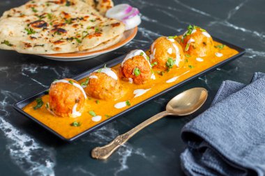 Zengin, baharatlı kaju soslu, yumuşak, kremalı malai kofta, sıcak, kabarık tereyağlı ve aromalı Kuzey Hindistan lezzeti ile mükemmel eşleştirilmiş..