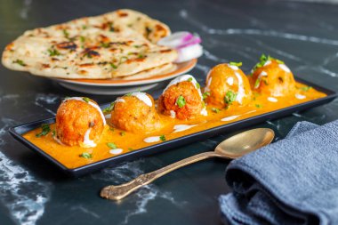 Zengin, baharatlı kaju soslu, yumuşak, kremalı malai kofta, sıcak, kabarık tereyağlı ve aromalı Kuzey Hindistan lezzeti ile mükemmel eşleştirilmiş..