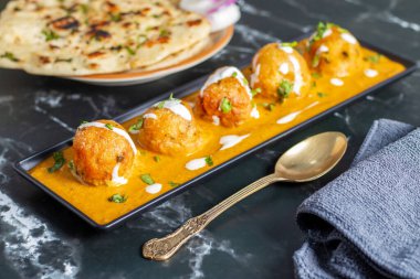 Zengin, baharatlı kaju soslu, yumuşak, kremalı malai kofta, sıcak, kabarık tereyağlı ve aromalı Kuzey Hindistan lezzeti ile mükemmel eşleştirilmiş..