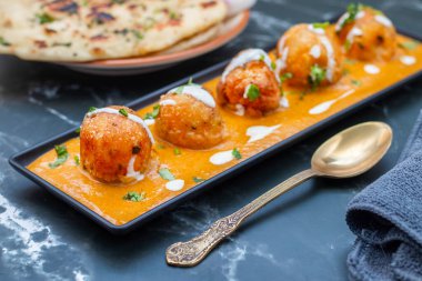 Zengin, baharatlı kaju soslu, yumuşak, kremalı malai kofta, sıcak, kabarık tereyağlı ve aromalı Kuzey Hindistan lezzeti ile mükemmel eşleştirilmiş..